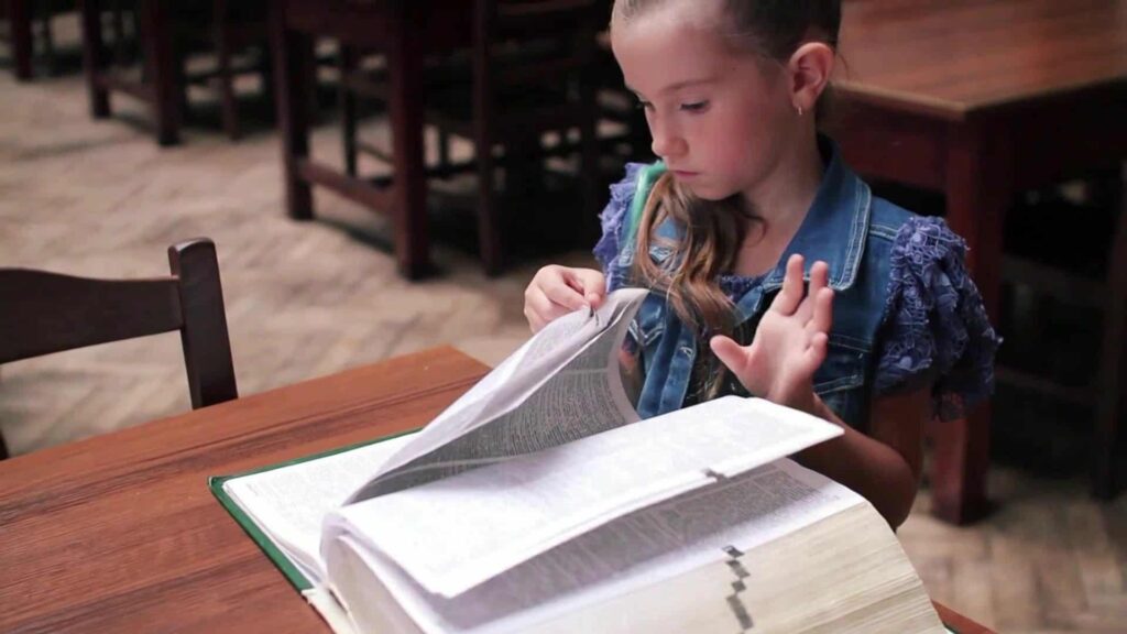 Une élève cherche dans le dictionnaire CE1 CE2