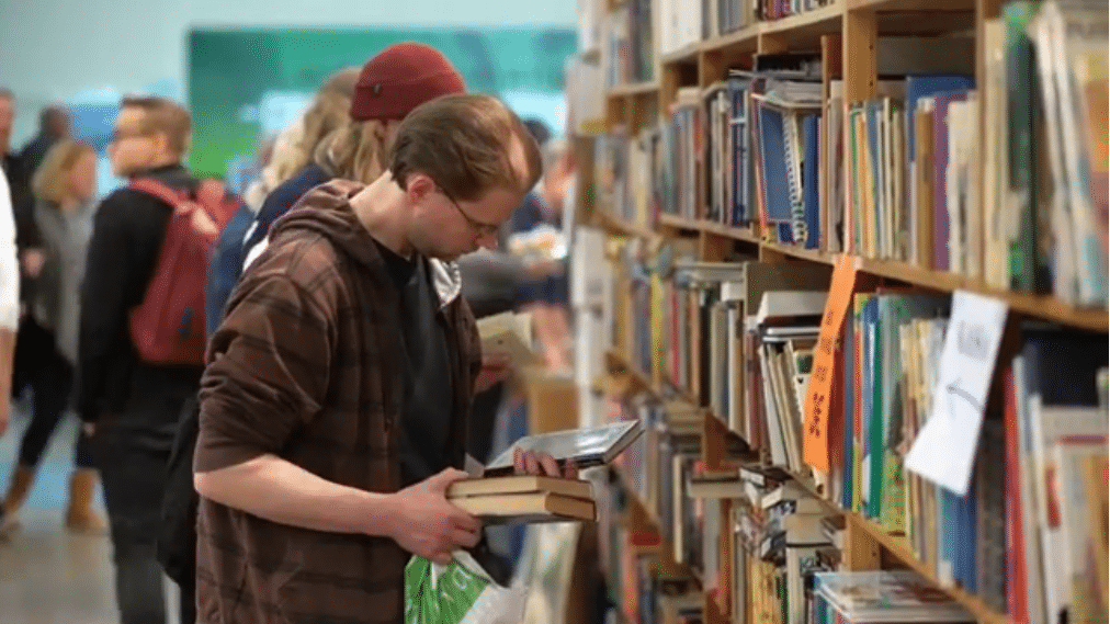 Un homme cherche un livre dans une bibliothèqye