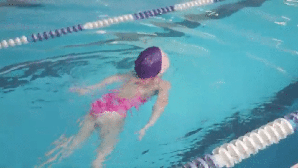 Une enfant fait de la natation en activité extra scolaire